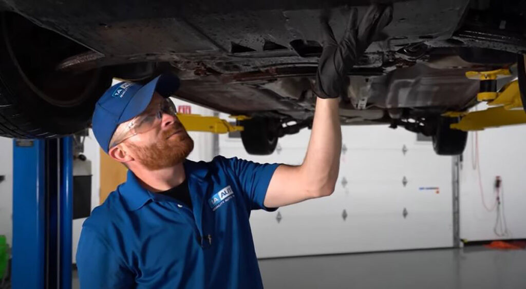 Mechanic showing what could cause a scraping noise while driving