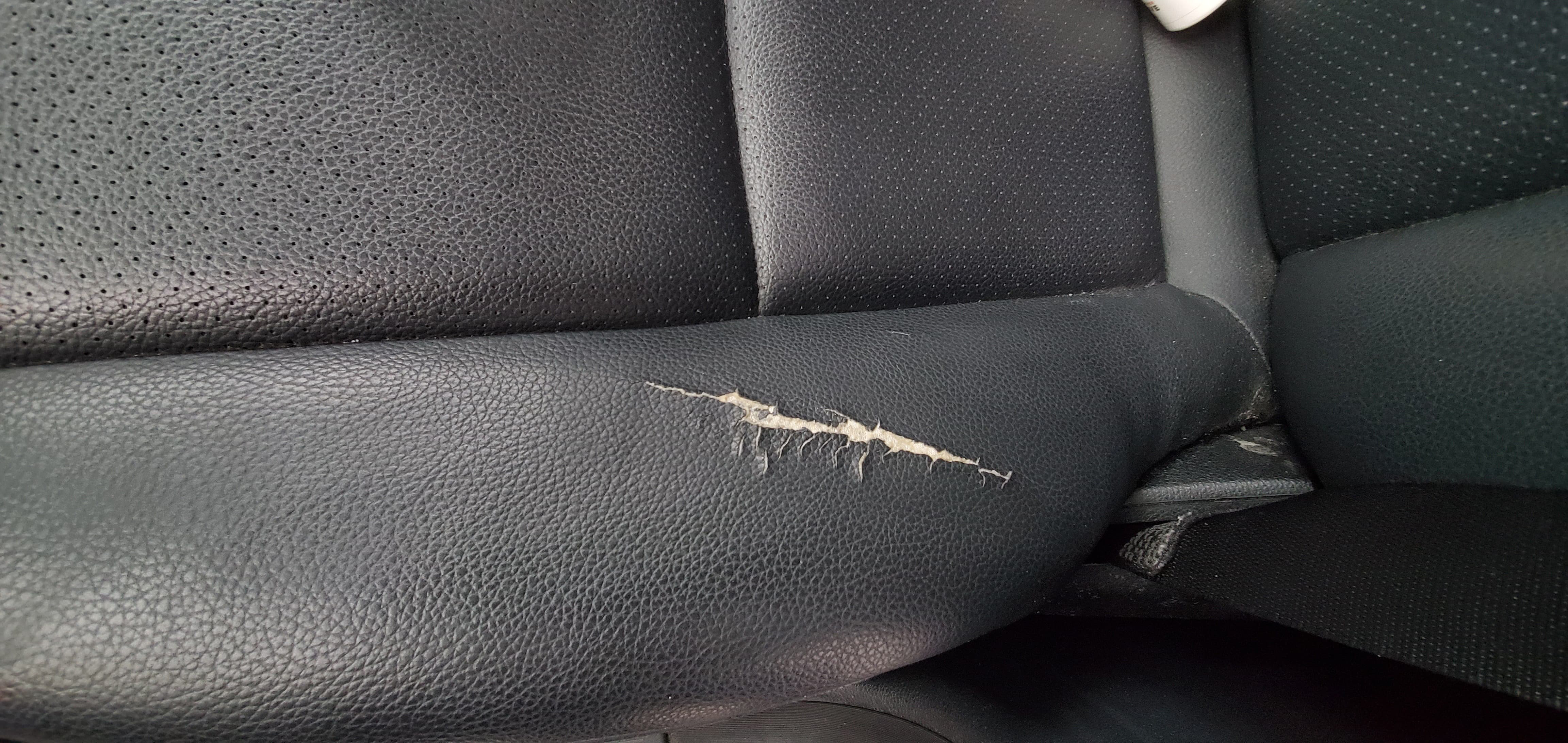 Before image of cracked leather car seat needing repair