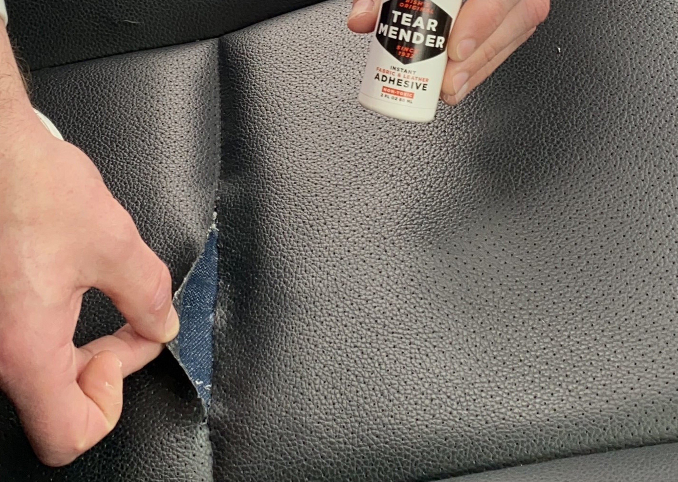 Denim patch being placed inside the tear of a leather car seat