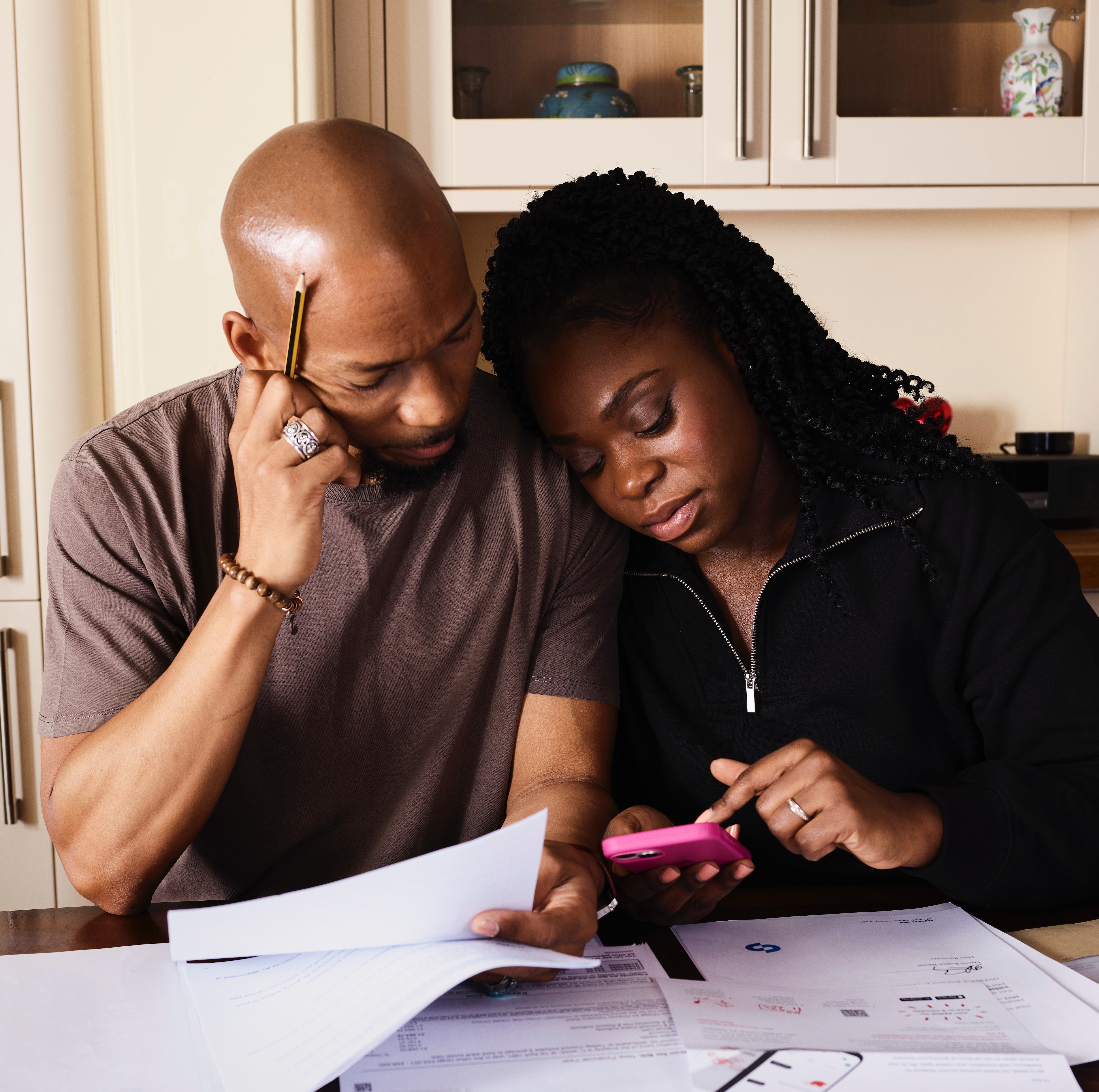 A couple looking concerned at bills, representing potential financial stress from car repairs