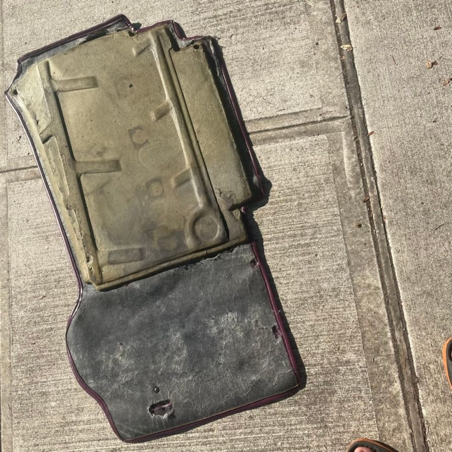 Damaged car mat backing showing cracks and material loss