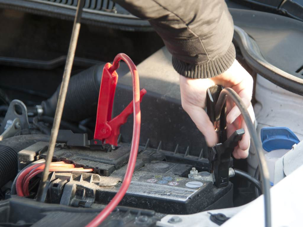 Using a battery charger to start a car without jumper cables.