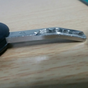 Bent car key example showing damage and distortion requiring professional repair