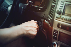 Man turning car key in ignition, demonstrating starting a car