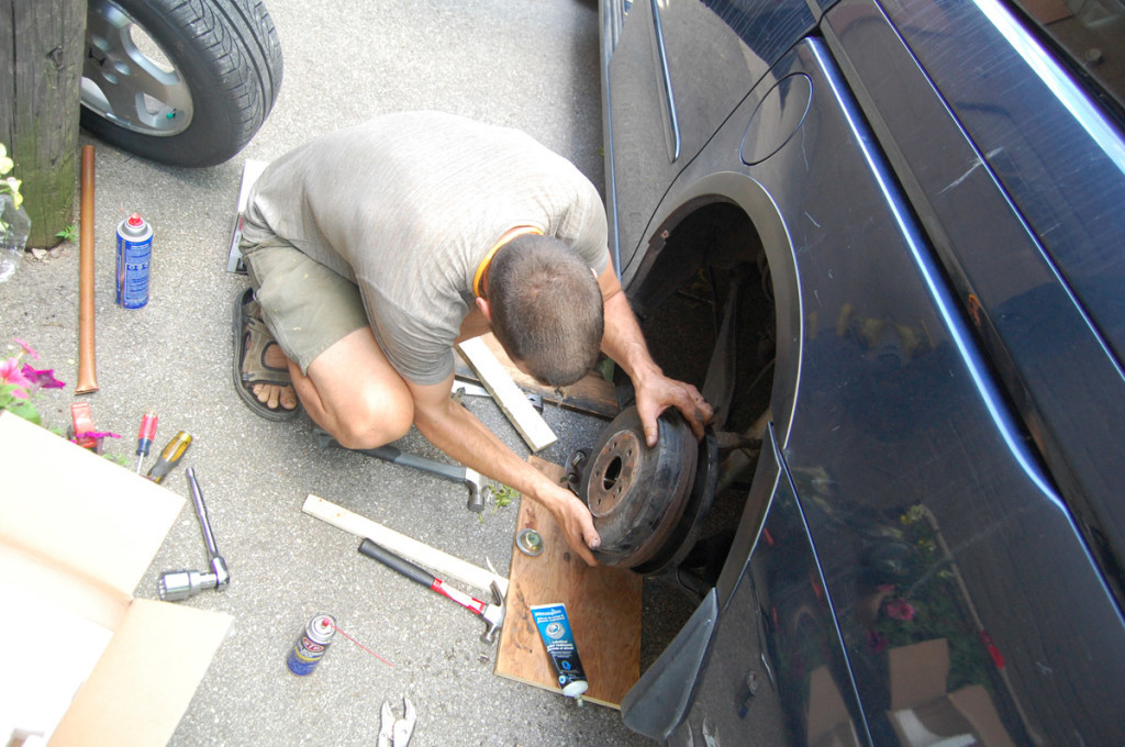 Removing the brake drum after taking off the wheel, revealing brake shoes.