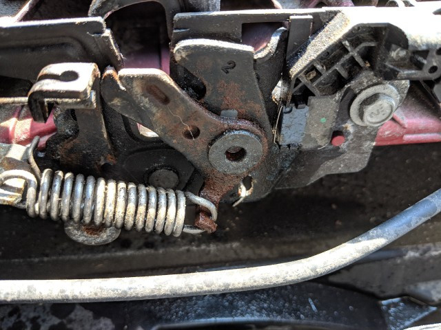 Car hood latch mechanism in a half-open position, indicating a problem with closing.