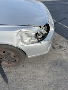 Extensive car dent on a curved panel with paint damage