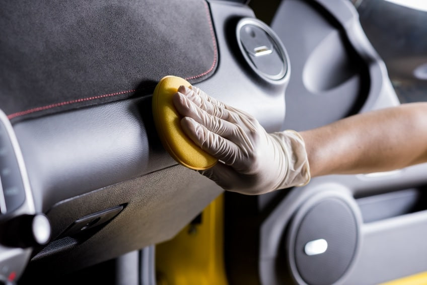 Close up of person cleaning car interior with microfiber cloth