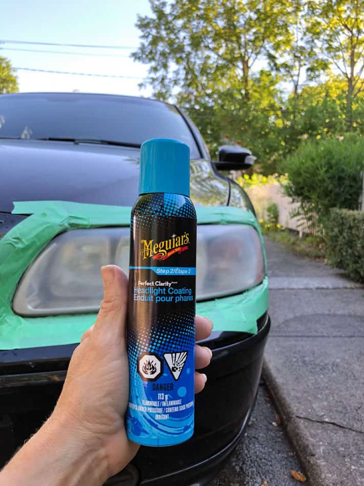 Applying Meguiar's headlight clear coat spray to a car headlight.