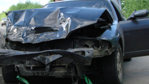 Car with severe front-end damage, including a crushed front, crumpled hood, and broken windshield