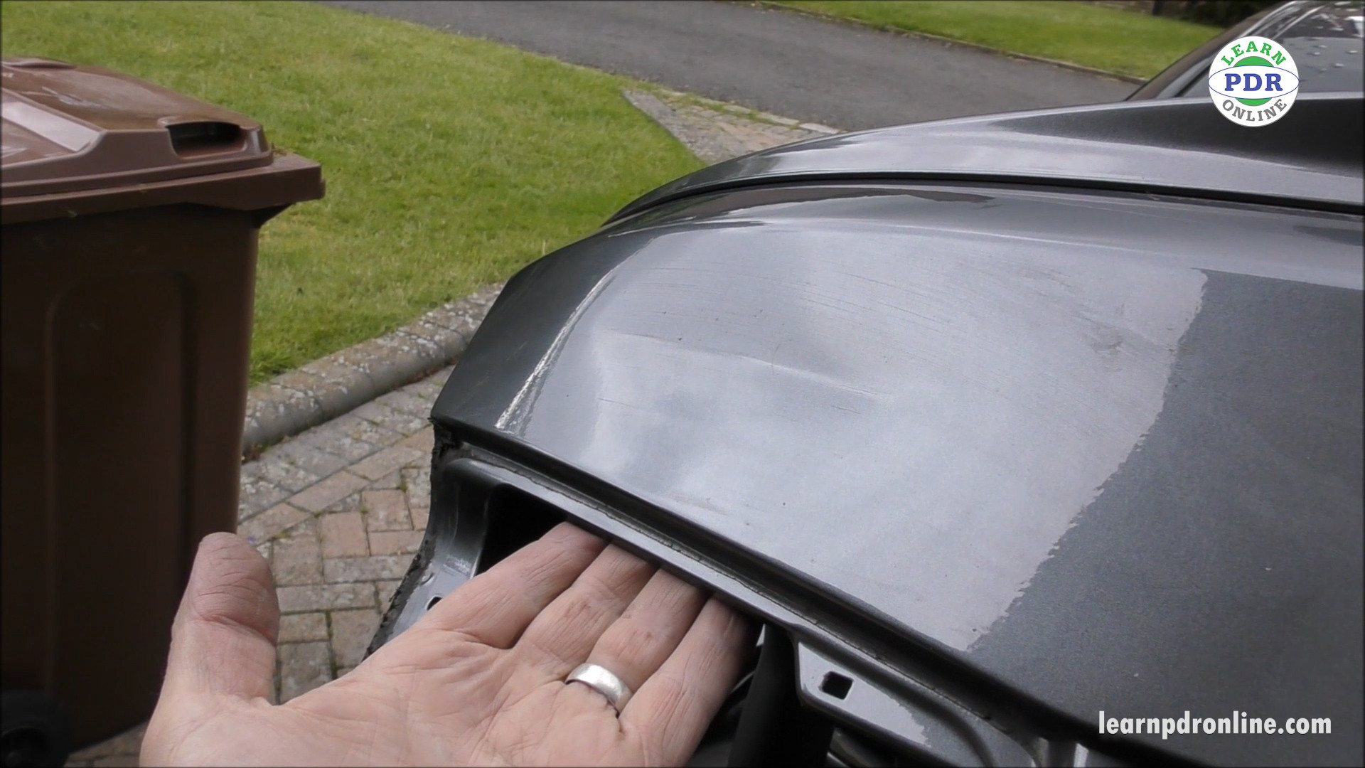 Assessing crease dent damage on a car boot lid, showing the location and severity of the dent.