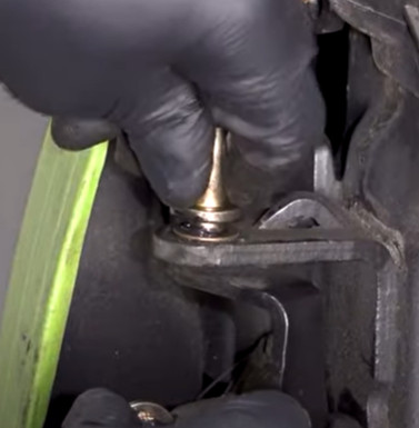 Hands replacing car door hinge bushings