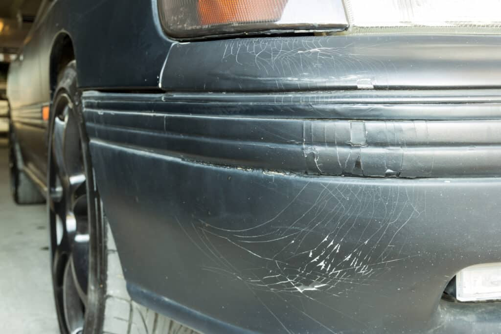 Close-up of a car's front bumper, showing minor scratches.