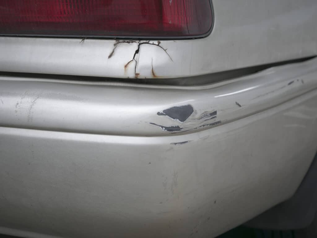 Close-up of a cracked car bumper, illustrating typical damage requiring repair.