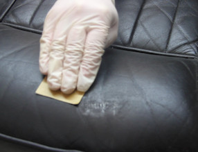 Sanding the dried leather filler to level the surface