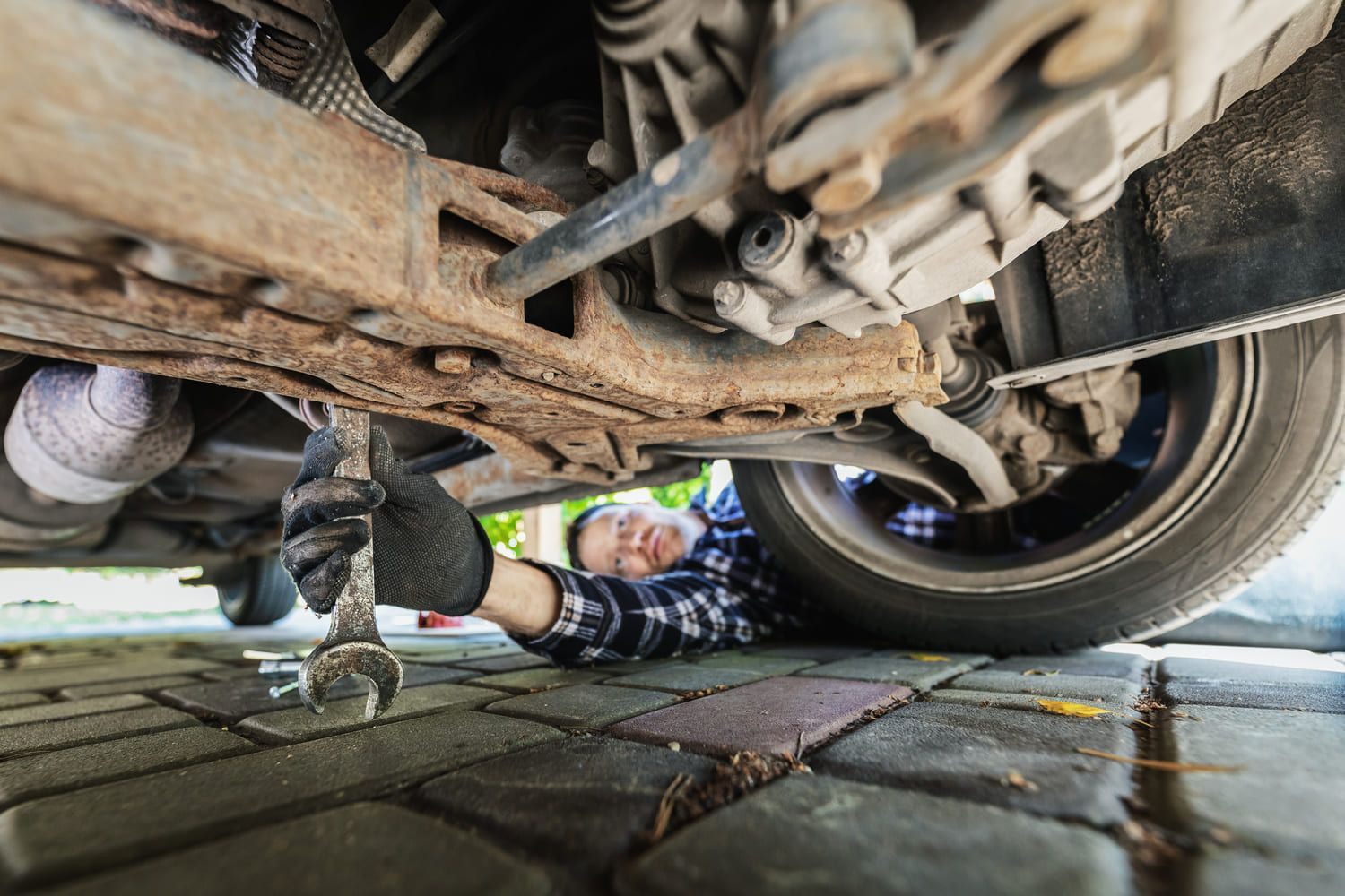 Man using sandpaper to remove rust from a car panel