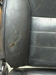 Tidying the damaged area of a leather car seat by removing loose leather lip