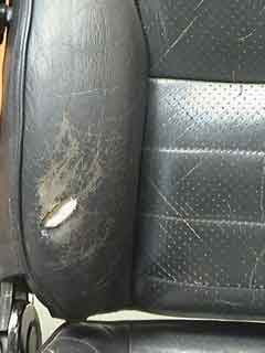 Applying a leather repair sub-patch to the underside of a hole in a car seat