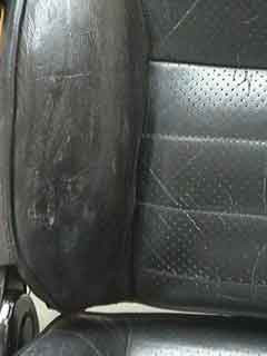 Applying initial coat of leather colorant to the repaired area of a car seat