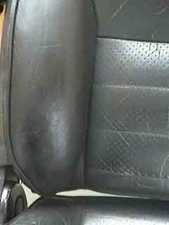 Spraying thin coats of leather colorant to blend the car seat repair and applying finish for protection