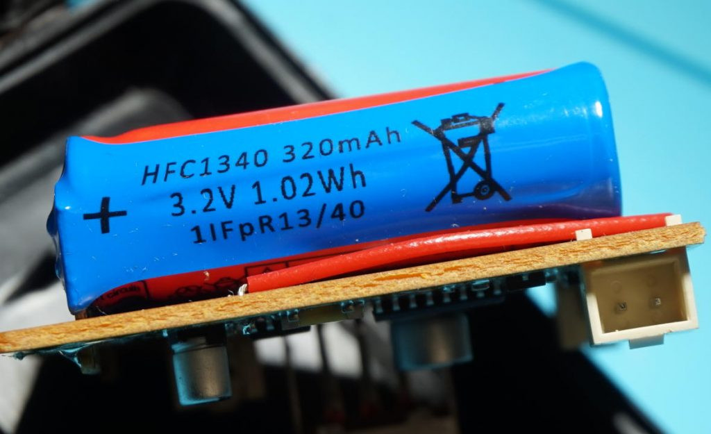 Close-up of the lithium iron phosphate batteries inside a New Bright RC car, a common component needing replacement in RC car repairs.