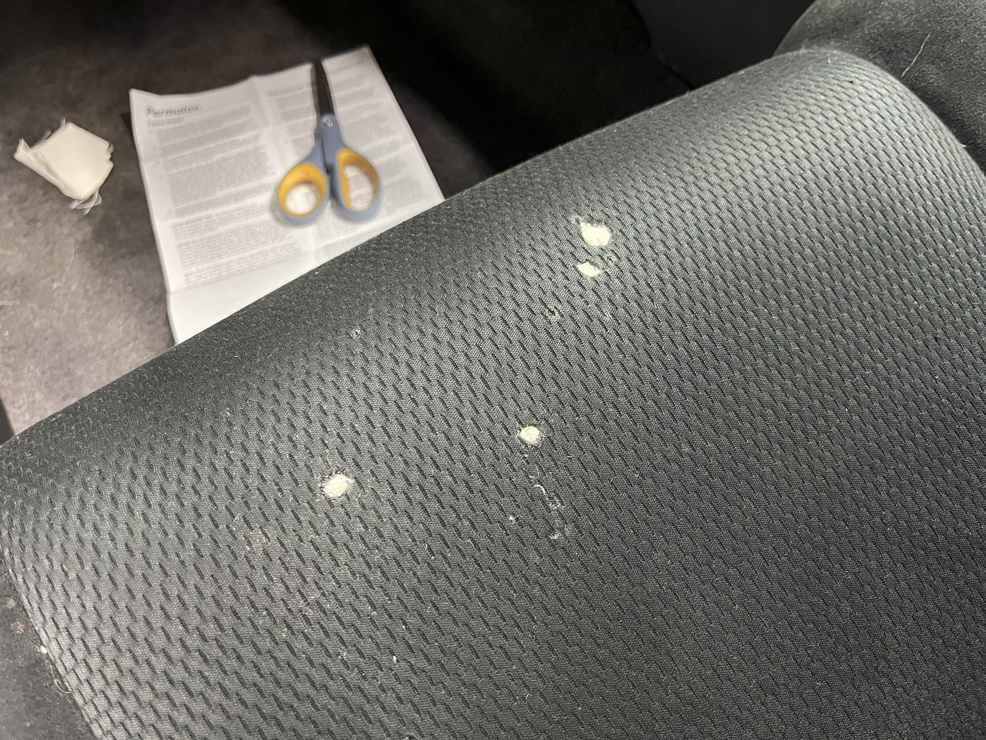 Applying adhesive to a fabric patch for car seat repair