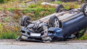 Car flipped on its roof showing extensive damage from a rollover accident