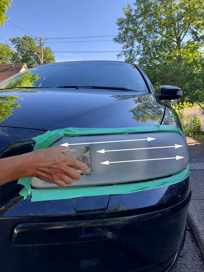 Horizontal sanding of a cloudy headlight using 800 grit sandpaper.