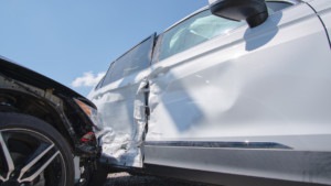 Car with side-impact damage, showing a crushed door and side panel typical of major collision repairs