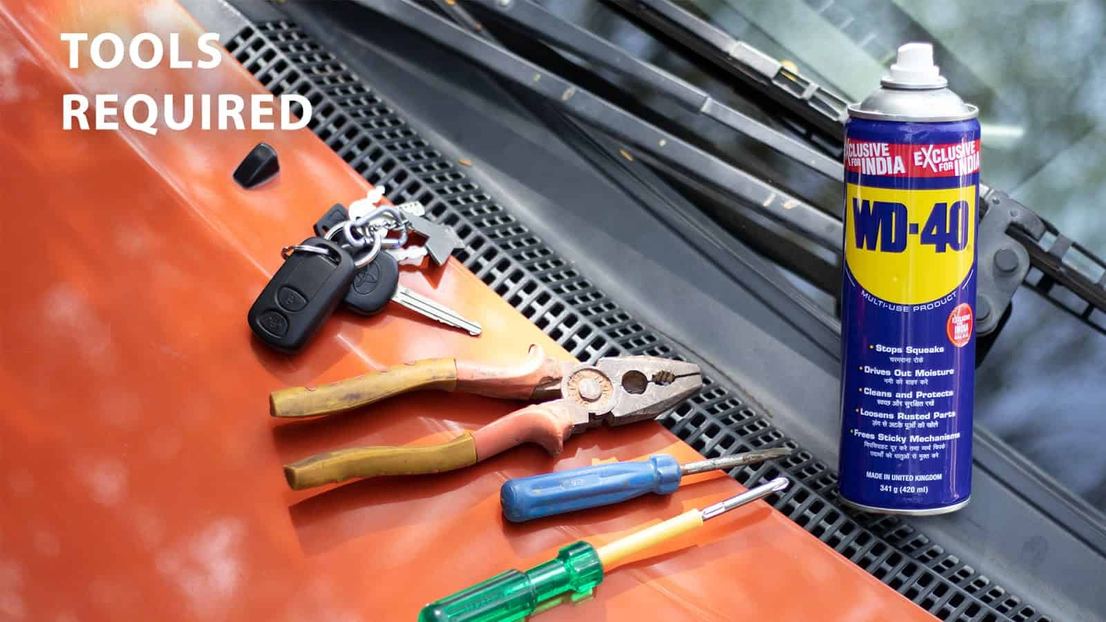 Tools needed to fix a jammed car lock: Needle nose pliers, screwdriver, WD-40 lubricant spray, flathead screwdriver, and a car key.