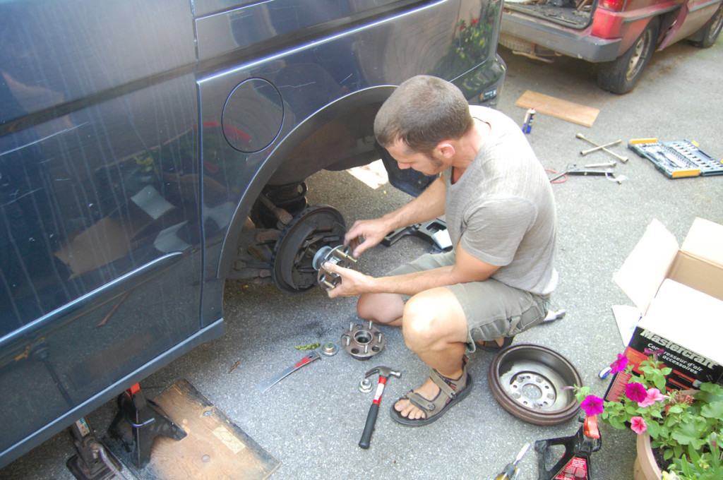 The new hub being carefully installed onto the axle with tapping and grease for smooth fitting.