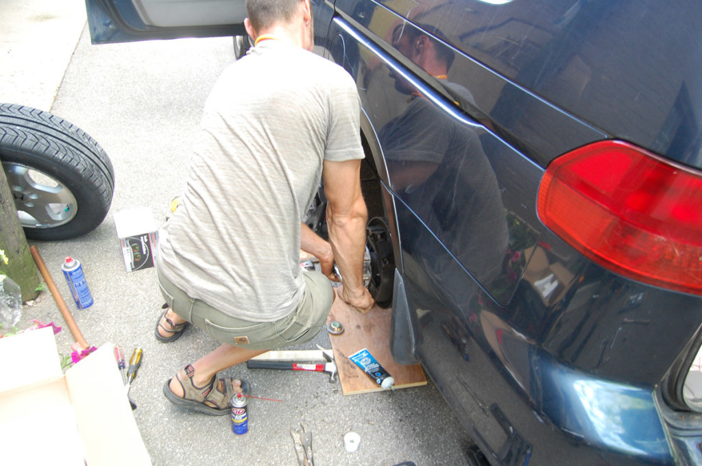 Tightening the spindle nut with a socket wrench to secure the new wheel hub assembly.